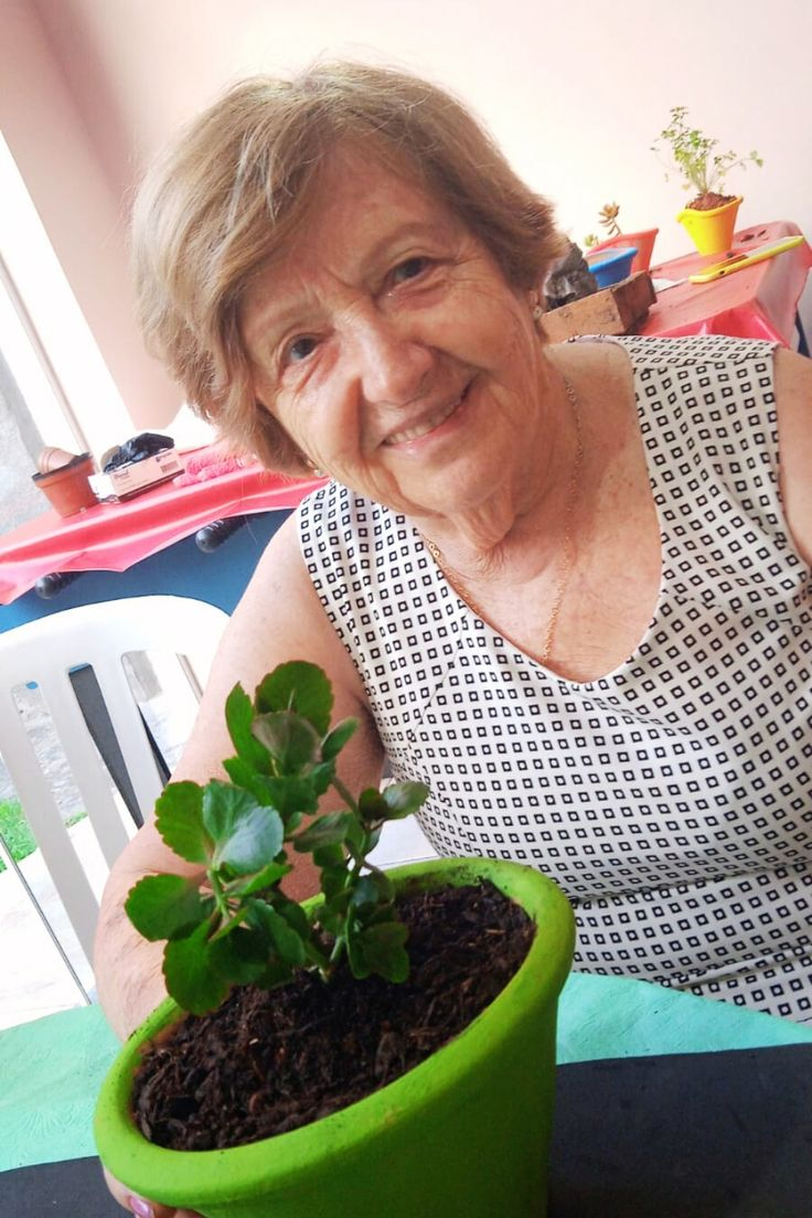 Maria, 72 anos, cuidando de suas plantas